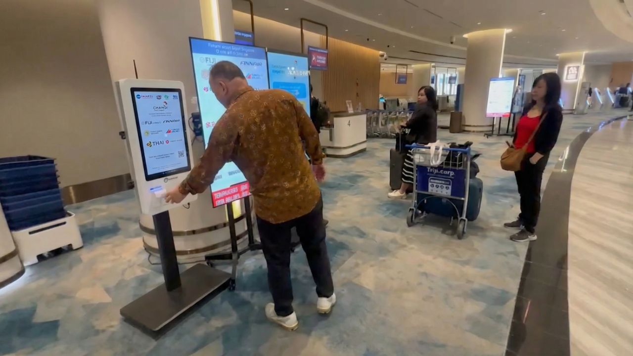 person using qwaiting self service kiosk at changi airport
